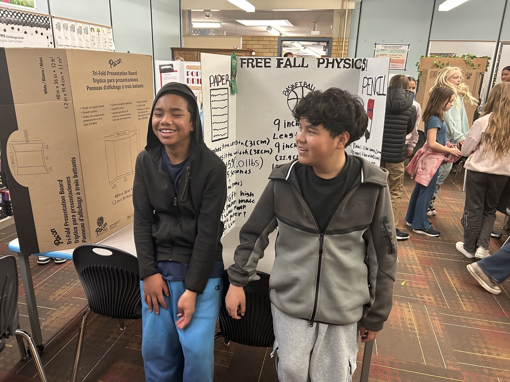 2 students standing in front of their team science project