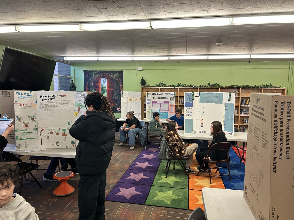 a library full of students showing off their science projects