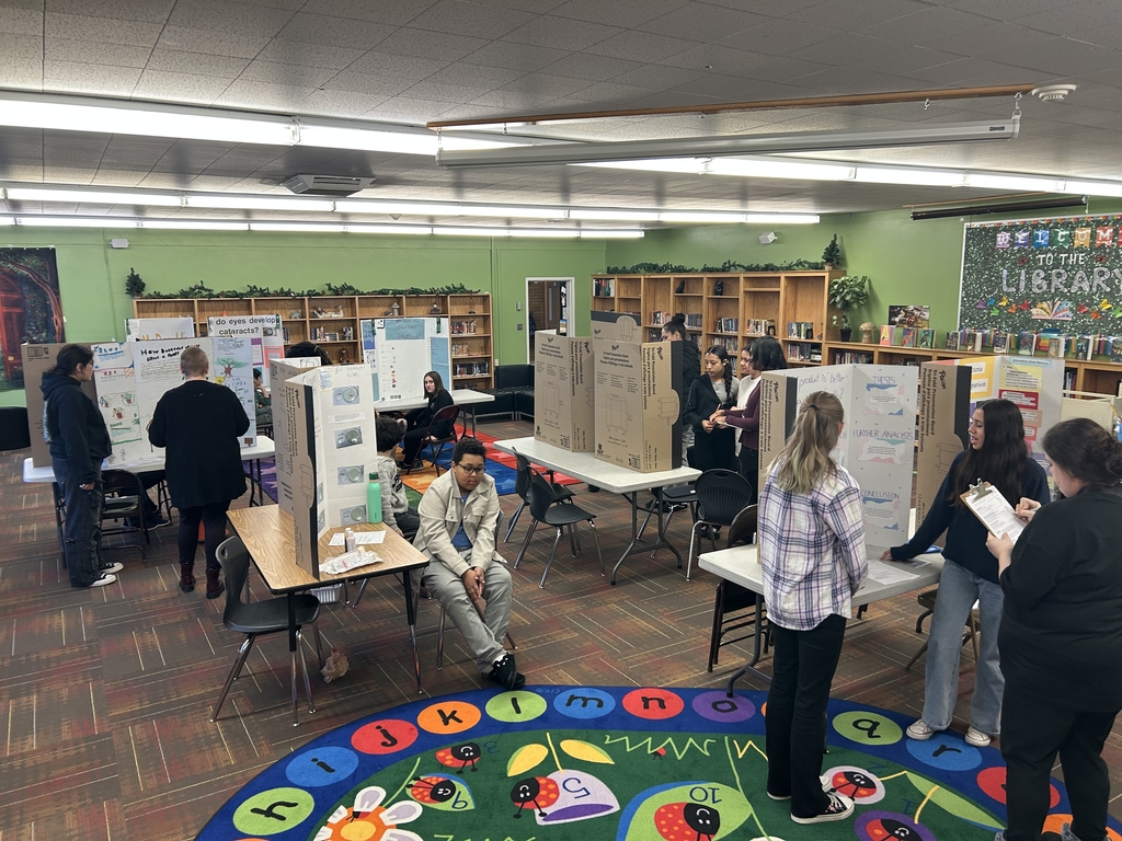 a library full of students showing off their science projects