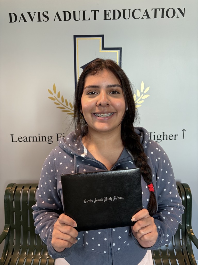 a picture of Auris Marquez holding her adult high school diploma
