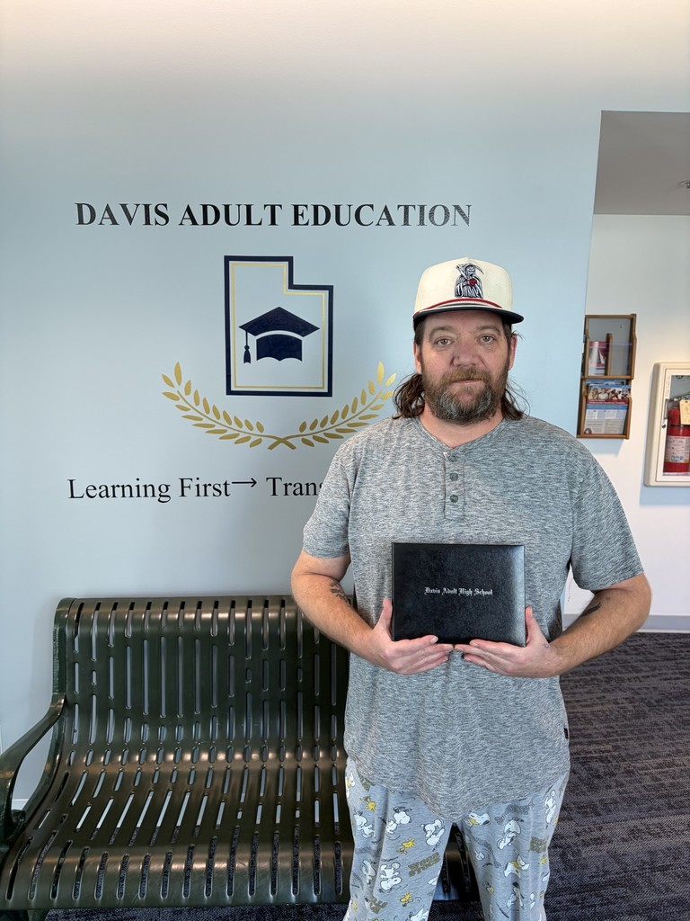 a picture of Richard Pryor holding his Davis Adult high school diploma