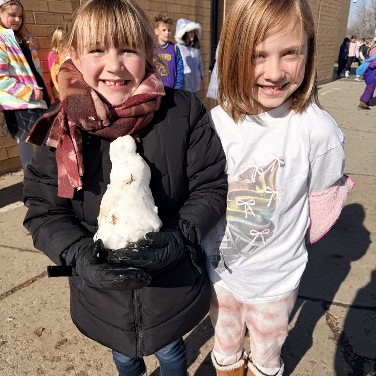 students showing a snowman they made during recess