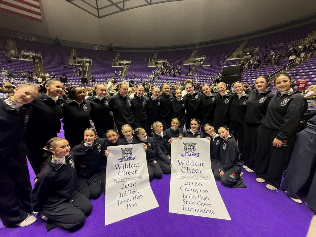 image of the kjh cheerleaders holding banners with the weber state wildcat logo announcing them first place in show cheer and 3rd place in pom