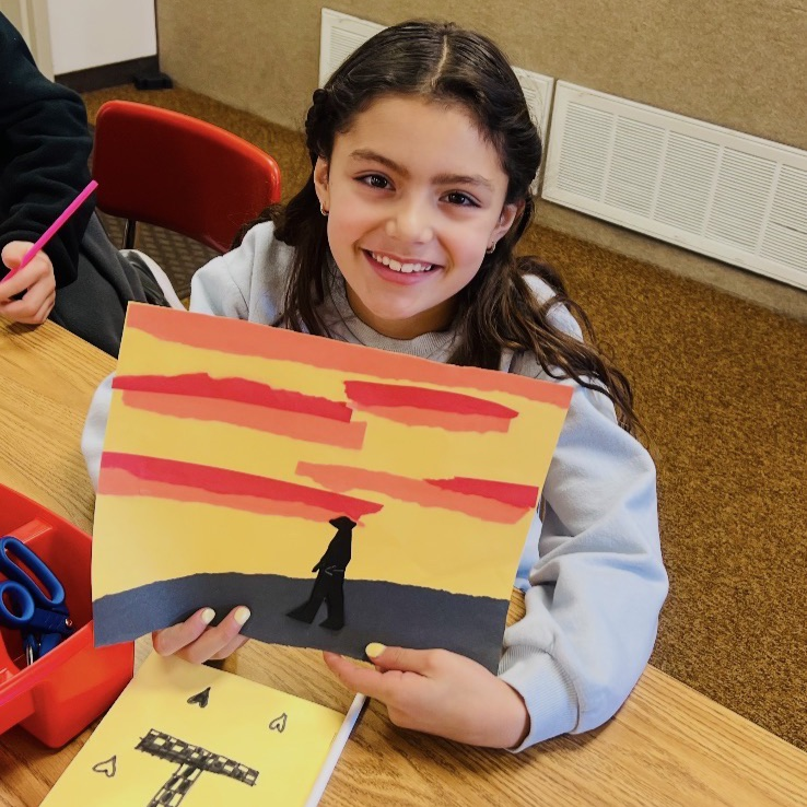 student showing their artwork creation