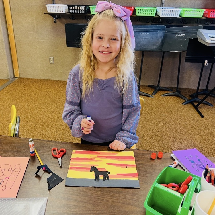 student showing their artwork creation