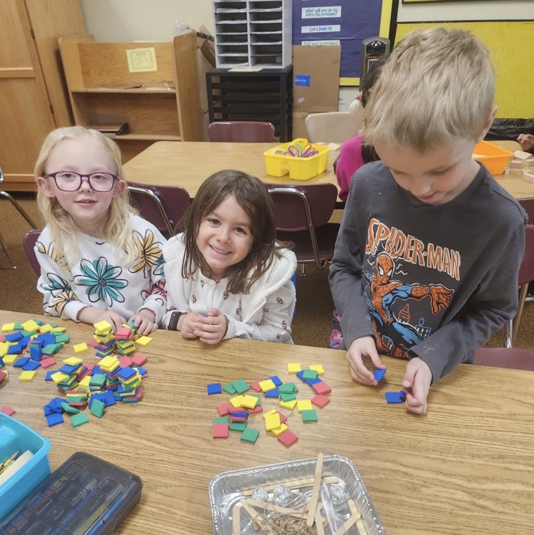 students using materials and working together as a team on their task