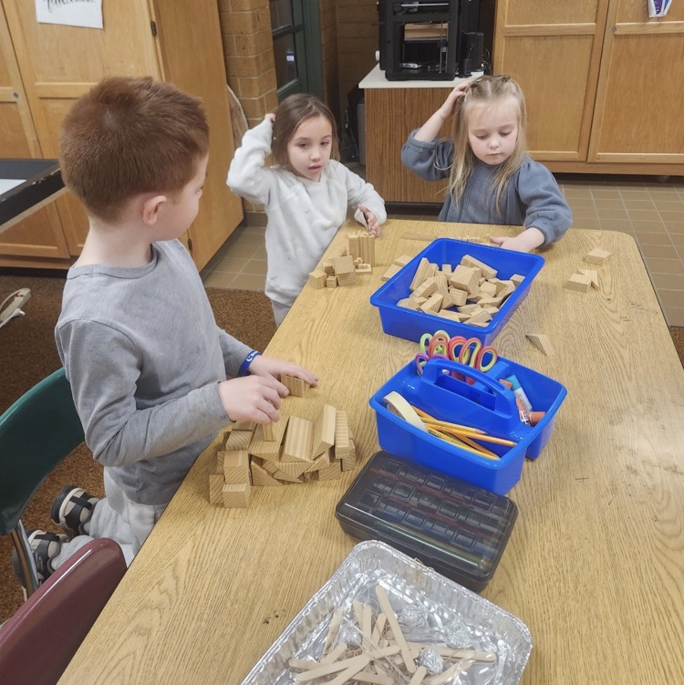 students using materials and working together as a team on their task