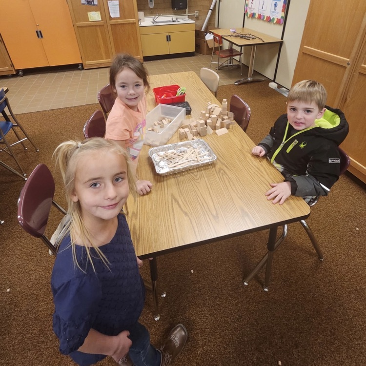 students using materials and working together as a team on their task