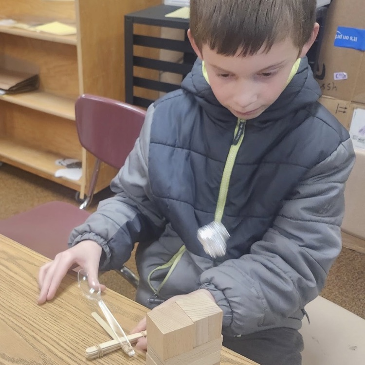 students using materials and working together as a team on their task