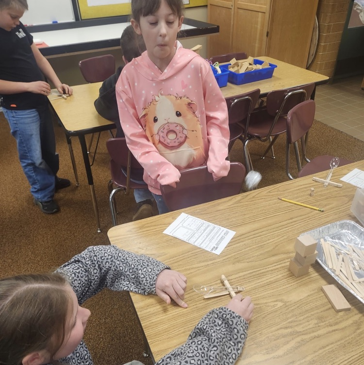 students using materials and working together as a team on their task