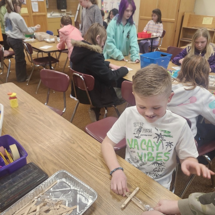 students using materials and working together as a team on their task