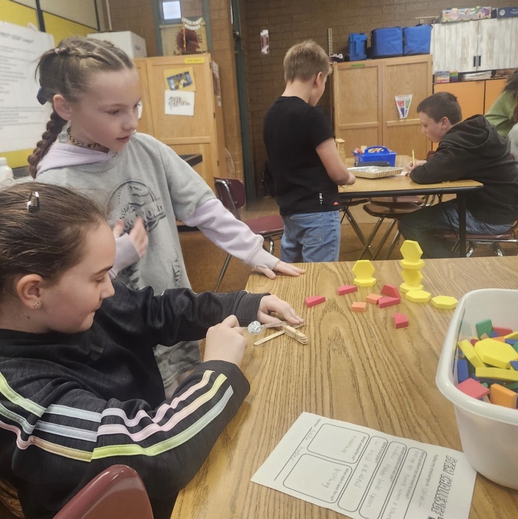 students using materials and working together as a team on their task