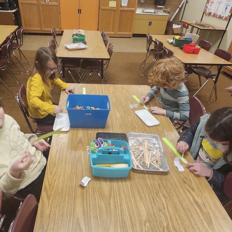 students using materials and working together as a team on their task