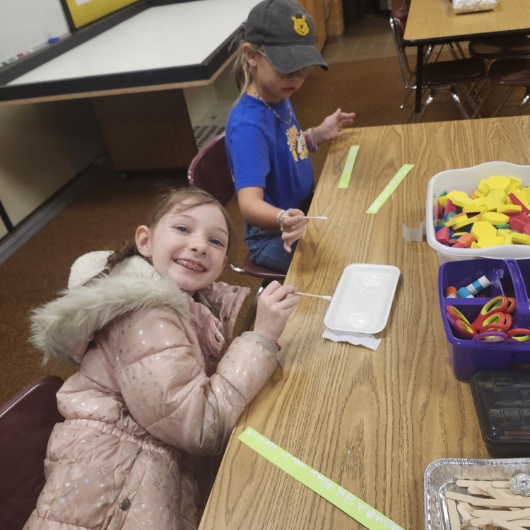 students using materials and working together as a team on their task