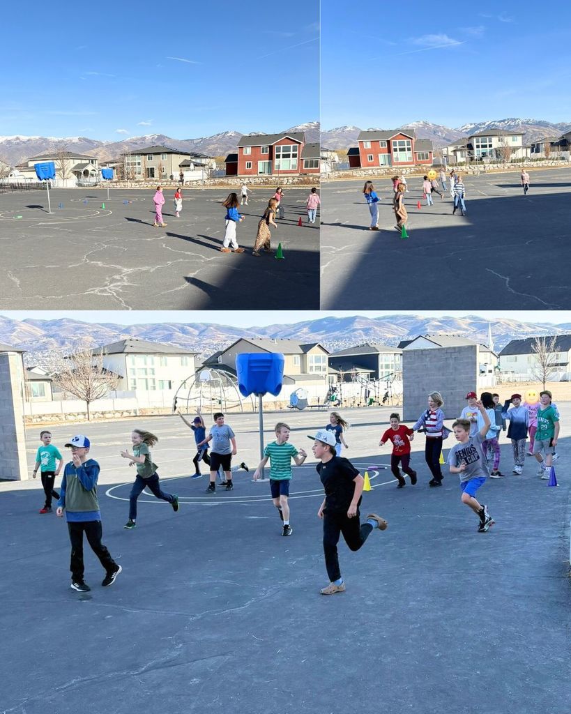 Elementary students running and playing capture the flag on a blacktop playground marked with cones. Houses and mountains are visible in the background under a clear blue sky.