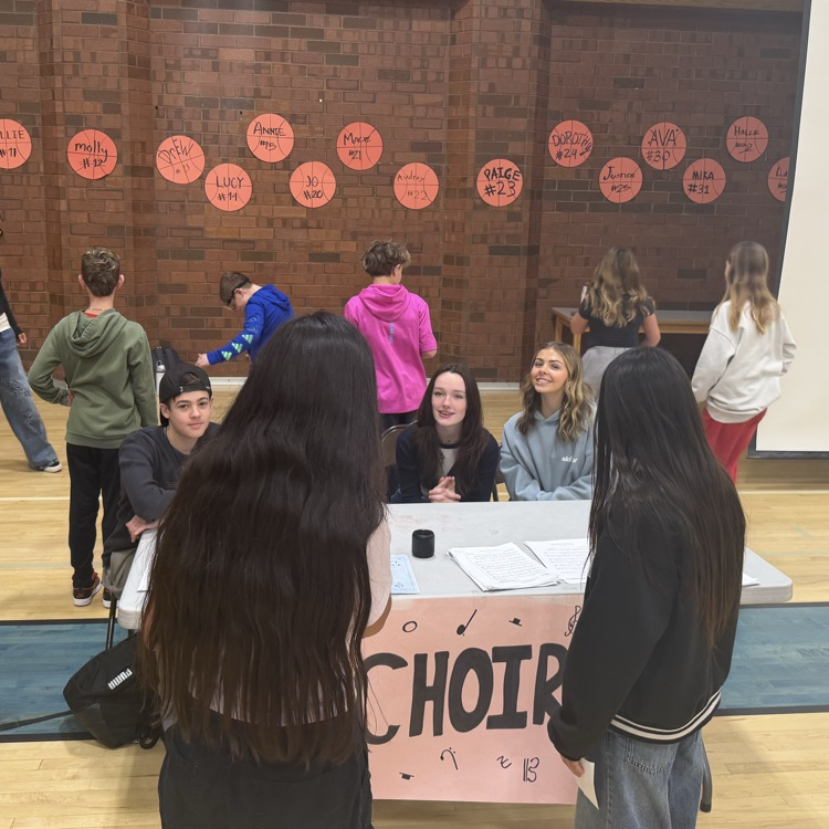 choir students explain to 2 students how fun choir classes are