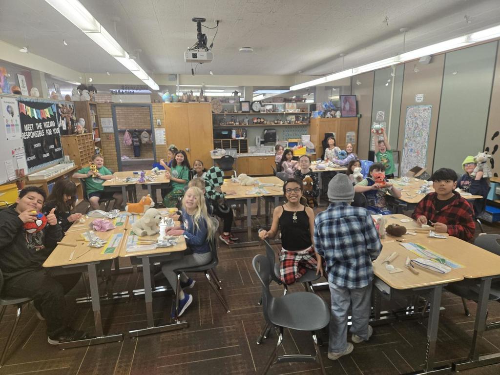 4th grade students working on clay art and showing off their stuffed animals