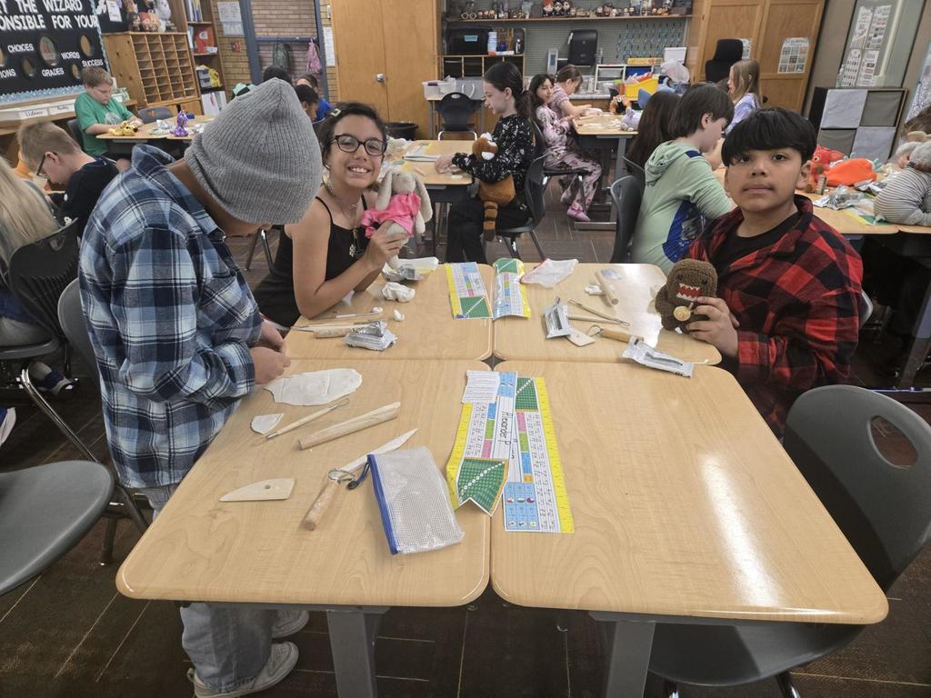 4th grade students working on clay art and showing off their stuffed animals