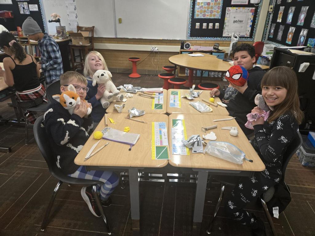 4th grade students working on clay art and showing off their stuffed animals