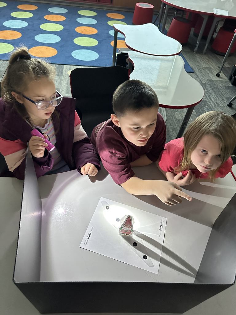 Students shining a light on an object.