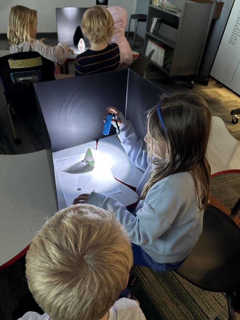 Students shining a light on an object.