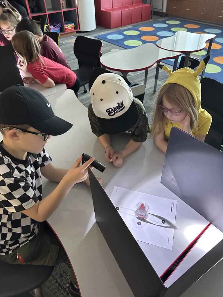 Students shining a light on an object.