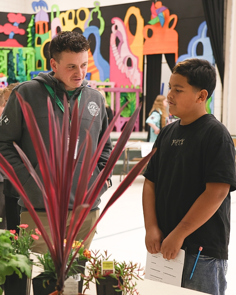 A student talking ato a usiness owner about plants. 