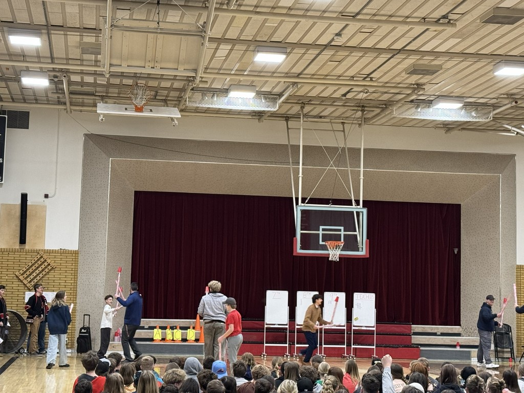 image of students with wrapping paper rolls and cups walking around