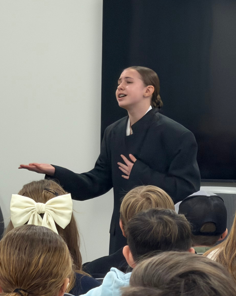 A student in a trench coat performs to her competition.