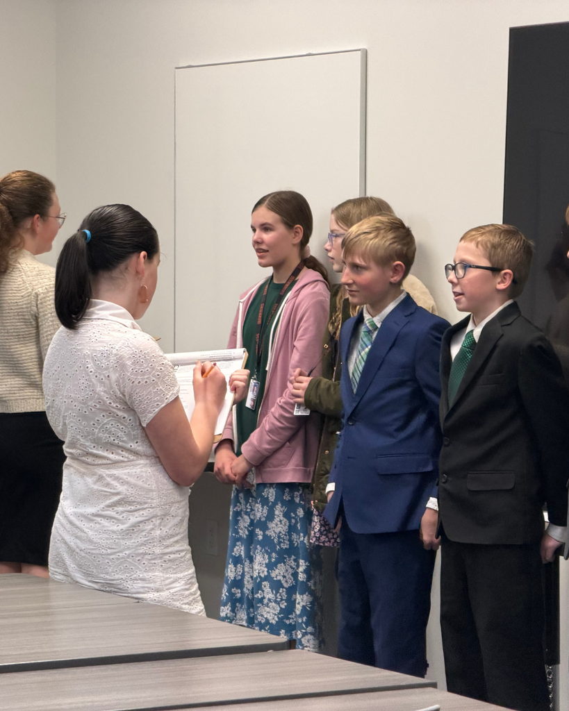 Students giving reports to other students in front of their poster boards. 