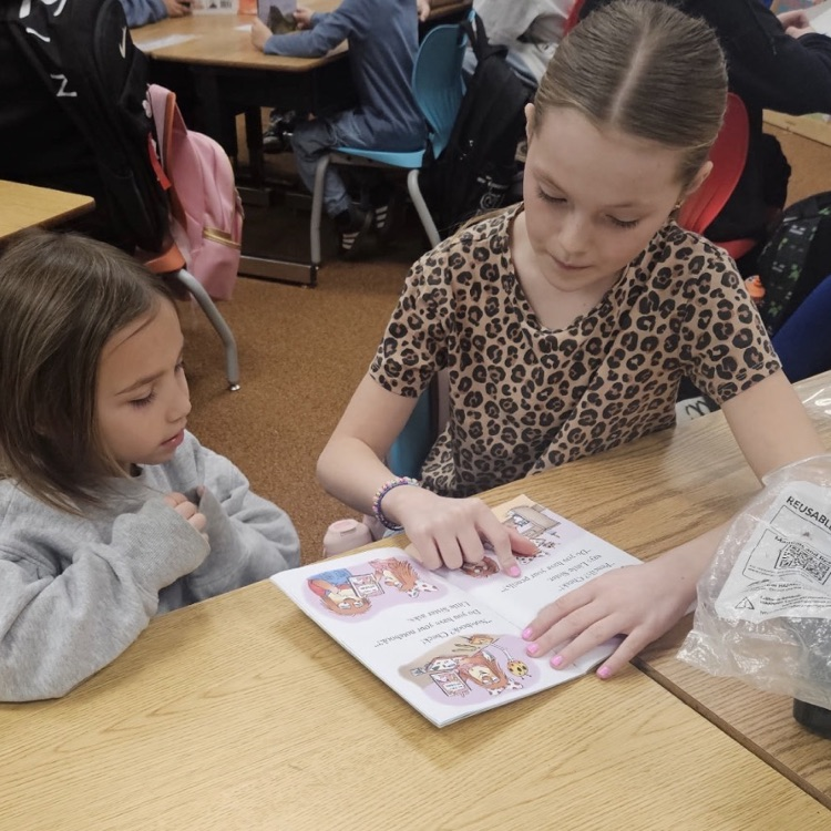 sixth grade and kindergarten students reading together