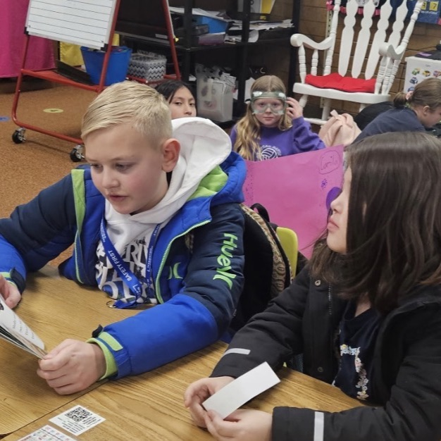 sixth grade and kindergarten students reading together