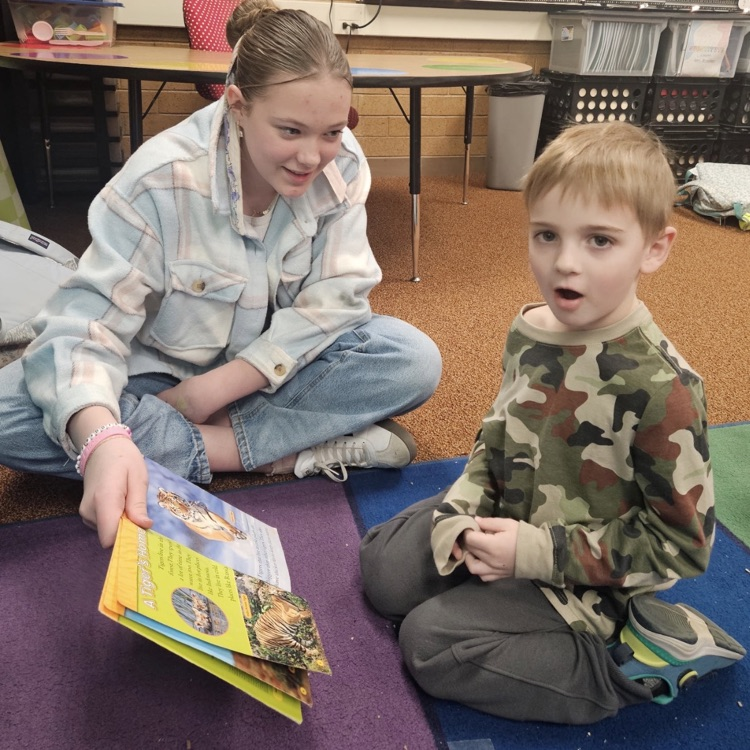 sixth grade and kindergarten students reading together