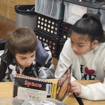 sixth grade and kindergarten students reading together