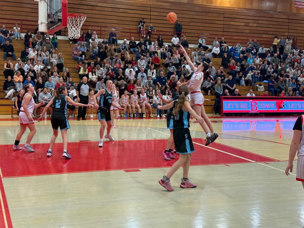 image of a girl jumping and shooting the basketball.