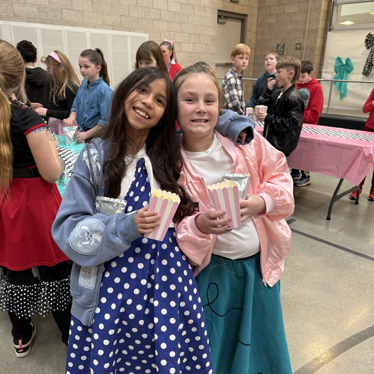 two girls in skirts smiling 