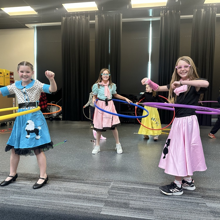 three girls in poodle skirts hula hooping