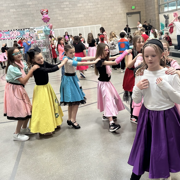 group of girls doing the bunny hop in poodle skirts