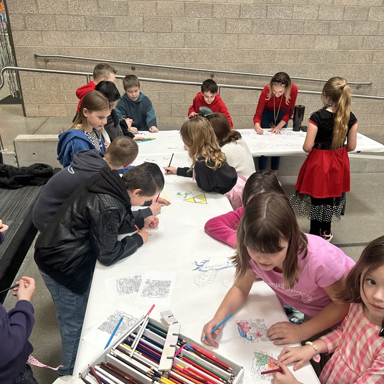 group of children coloring on white paper
