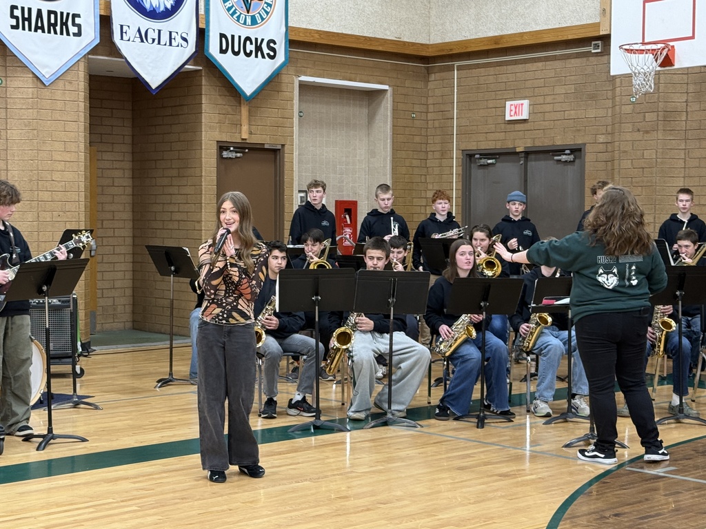 Student singing with the band at the assembly.