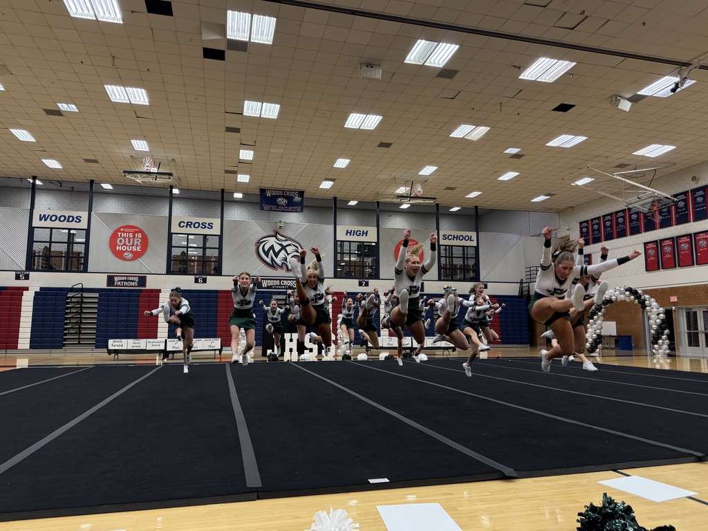 Cheerleaders jumping at the same time in their routine.