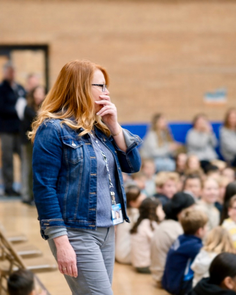 Surprise award assembly at Knowlton Elementary School where Shaunee McFadden receives the $10,000 Heidi Martin Mighty Heart Educator of Excellence Award, surrounded by students, district leaders and Foundation board members.
