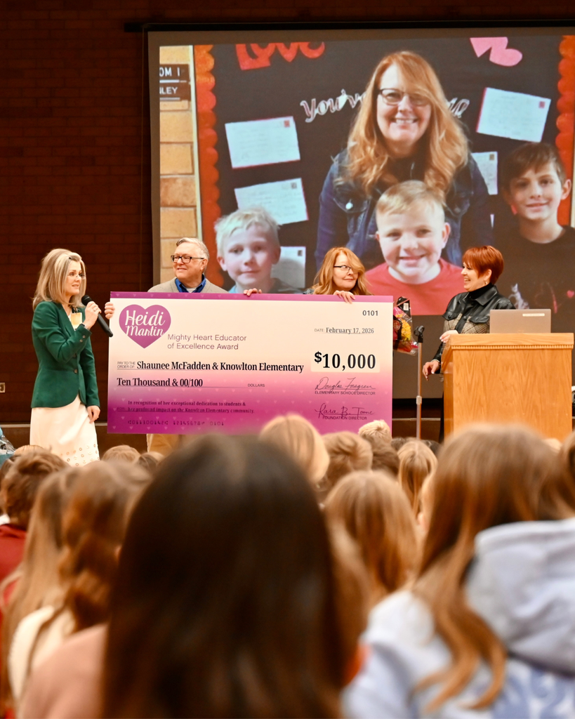 Surprise award assembly at Knowlton Elementary School where Shaunee McFadden receives the $10,000 Heidi Martin Mighty Heart Educator of Excellence Award, surrounded by students, district leaders and Foundation board members.