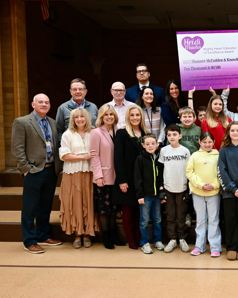 Surprise award assembly at Knowlton Elementary School where Shaunee McFadden receives the $10,000 Heidi Martin Mighty Heart Educator of Excellence Award, surrounded by students, district leaders and Foundation board members.