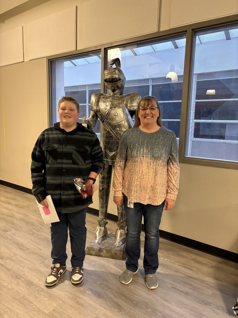 image of student and teacher standing in front of a knight statue