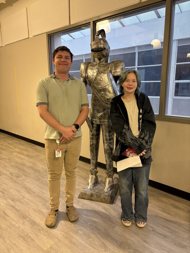 image of student and teacher standing in front of a knight statue