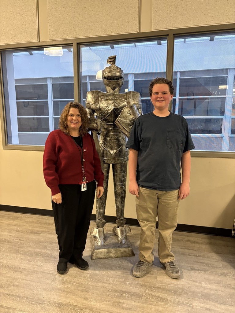 image of student and teacher standing in front of a knight statue