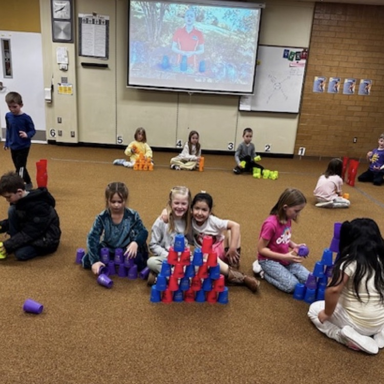 students practicing cup stacking speed drills and working together as teams during PE