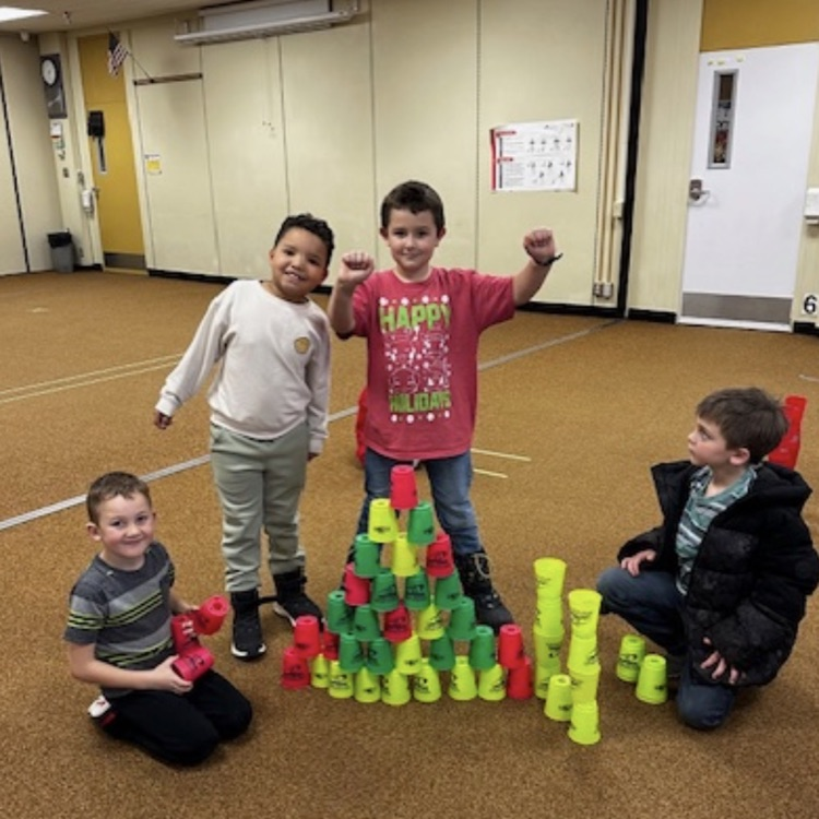 students practicing cup stacking speed drills and working together as teams during PE