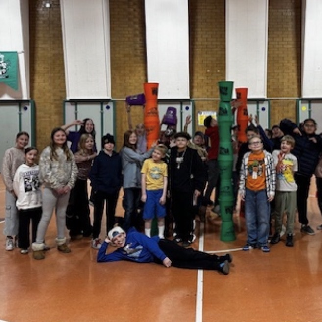 students practicing cup stacking speed drills and working together as teams during PE